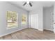 Light bedroom with a ceiling fan, two windows, and spacious closet for storage at 8112 N 10Th St, Tampa, FL 33604