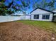 Backyard featuring lush grass and modern white fence and mature landscaping at 8209 Volusia Pl, Tampa, FL 33637