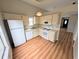 Bright kitchen featuring wood-look floors and white appliances at 8209 Volusia Pl, Tampa, FL 33637