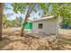 Backyard area with a detached white building and a green house visible behind the tree at 8215 N 14Th St, Tampa, FL 33604