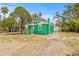 Angle view of charming green house with light roof, complementing lush surroundings at 8215 N 14Th St, Tampa, FL 33604