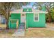 Charming green home featuring a welcoming porch and newly landscaped front yard at 8215 N 14Th St, Tampa, FL 33604