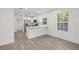 Open kitchen with stainless steel appliances, white cabinetry, and a breakfast bar, complemented by wood floors at 8215 N 14Th St, Tampa, FL 33604