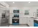 Bright, modern kitchen with stainless steel appliances, white subway tile, quartz counters, and a blue oven at 8215 N 14Th St, Tampa, FL 33604