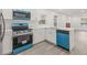 Modern kitchen showcasing white cabinetry, quartz countertops, and a stylish blue oven and dishwasher set at 8215 N 14Th St, Tampa, FL 33604