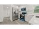 Modern kitchen boasts stainless steel refrigerator, white cabinets, quartz countertops, and sleek blue oven and microwave at 8215 N 14Th St, Tampa, FL 33604