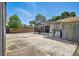Backyard concrete patio with view of the screened in porch, laundry area, and some trees at 8525 N Ola Ave, Tampa, FL 33604