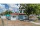 Charming single-story home featuring a light blue exterior, a cozy front yard, and a concrete walkway leading to the front door at 8525 N Ola Ave, Tampa, FL 33604