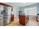 Bright kitchen features stainless steel refrigerator, center island with dark countertop, and tile flooring at 8525 N Ola Ave, Tampa, FL 33604