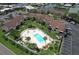 Aerial view showcasing a community pool, well-manicured lawns, and convenient parking for residents and guests alike at 1028 Apollo Beach Blvd # 203, Apollo Beach, FL 33572