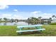 A waterfront view with a bench and lush green space under a blue sky at 1028 Apollo Beach Blvd # 203, Apollo Beach, FL 33572