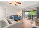 Bright living room featuring hardwood floors, a comfortable couch, and sliding doors to the outdoor balcony at 1028 Apollo Beach Blvd # 203, Apollo Beach, FL 33572
