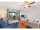 Relax in this living room with balcony, hardwood floors, and fan at 1028 Apollo Beach Blvd # 203, Apollo Beach, FL 33572