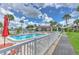 Inviting community pool with ample seating and lush tropical landscaping on a bright, sunny day at 1028 Apollo Beach Blvd # 203, Apollo Beach, FL 33572
