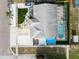 Aerial view of a home with a screened pool, well-manicured lawn, and solar panels on the roof at 1102 Goshen Rd, Tarpon Springs, FL 34689