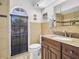 Bathroom with dark wood vanity, granite countertop, and window at 1102 Goshen Rd, Tarpon Springs, FL 34689