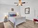 Cozy bedroom with a white bed frame, wood floors, and a modern ceiling fan with light at 1102 Goshen Rd, Tarpon Springs, FL 34689