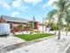 Charming single-story home with well-manicured lawn, palm trees, and lovely landscaping at 1102 Goshen Rd, Tarpon Springs, FL 34689