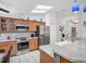 Bright kitchen showcasing stainless steel appliances, tile backsplash, and stone countertops with a breakfast bar at 1102 Goshen Rd, Tarpon Springs, FL 34689
