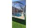 A refreshing screened-in pool with sun-drenched leisure space and artificial lawn for comfortable relaxation at 1102 Goshen Rd, Tarpon Springs, FL 34689