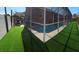 A stunning screened-in pool area with ample space for outdoor seating and entertainment on an artificial lawn at 1102 Goshen Rd, Tarpon Springs, FL 34689