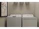 Convenient laundry room featuring a modern washer and dryer set with shelving for organized storage at 11084 E 65Th Ter, Palmetto, FL 34221