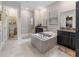 Spacious bathroom boasts a soaking tub, a separate shower, and dual sinks with elegant black vanities at 11714 Sunburst Marble Rd, Riverview, FL 33579