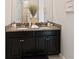 Bathroom features dual sinks with granite counters, dark cabinetry, and modern fixtures for a stylish look at 11714 Sunburst Marble Rd, Riverview, FL 33579