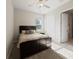 Bright bedroom featuring a dark wood bed, ceiling fan, and two windows, with an open door to another room at 11714 Sunburst Marble Rd, Riverview, FL 33579