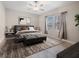 A cozy bedroom featuring a ceiling fan, modern decor, and lots of natural light from the large window at 11714 Sunburst Marble Rd, Riverview, FL 33579