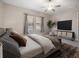 Comfortable bedroom showcasing a contemporary design, a large TV, and a serene view from the window at 11714 Sunburst Marble Rd, Riverview, FL 33579
