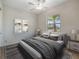 Relaxing bedroom showcasing neutral tones, a large window, and modern artwork for a peaceful retreat at 11714 Sunburst Marble Rd, Riverview, FL 33579