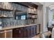Modern bar area featuring custom cabinetry, a wine cooler, and stylish tile work at 1325 Snell Isle Ne Blvd # 708, St Petersburg, FL 33704