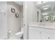 Neat bathroom featuring white cabinets, a toilet, mirror, and decorative lighting at 1325 Snell Isle Ne Blvd # 708, St Petersburg, FL 33704