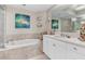 Luxurious bathroom with soaking tub, stylish vanity, decorative art, and glass enclosed shower at 1325 Snell Isle Ne Blvd # 708, St Petersburg, FL 33704