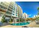 View of the building exterior with balconies and a shared in-ground pool with palm trees at 1325 Snell Isle Ne Blvd # 708, St Petersburg, FL 33704
