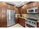 Modern kitchen with stainless steel appliances, granite countertops, and warm wood cabinets at 1325 Snell Isle Ne Blvd # 708, St Petersburg, FL 33704