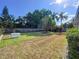 Grassy backyard featuring mature trees and a Generac generator system at 13725 Oak Forest N Blvd, Seminole, FL 33776