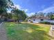 Spacious backyard featuring lush green grass, mature trees, and screened porch at 13725 Oak Forest N Blvd, Seminole, FL 33776