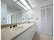 Bright bathroom featuring a double sink vanity, a large mirror, and closet at 13725 Oak Forest N Blvd, Seminole, FL 33776