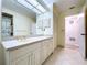 Bathroom with double vanity, tile flooring, and decorative mirror at 13725 Oak Forest N Blvd, Seminole, FL 33776