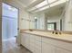 Bright bathroom featuring a double sink vanity, a large mirror, and tile flooring at 13725 Oak Forest N Blvd, Seminole, FL 33776
