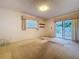 Bright bedroom with carpet flooring, sliding glass doors, and a window at 13725 Oak Forest N Blvd, Seminole, FL 33776
