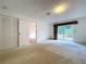 Spacious carpeted bedroom with closet and sliding glass door at 13725 Oak Forest N Blvd, Seminole, FL 33776