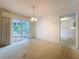 Bright dining room with a chandelier, sliding glass doors to the patio, and an open view to other rooms at 13725 Oak Forest N Blvd, Seminole, FL 33776