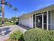 Close up of the home showing a two-car garage and decorative screen door with mature landscaping at 13725 Oak Forest N Blvd, Seminole, FL 33776