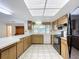 Bright kitchen featuring breakfast bar, black appliances, and window at 13725 Oak Forest N Blvd, Seminole, FL 33776