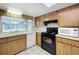 Charming kitchen with window view and black appliances at 13725 Oak Forest N Blvd, Seminole, FL 33776