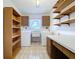Bright laundry room with washer, dryer, built-in shelves, cabinets, and a utility sink at 13725 Oak Forest N Blvd, Seminole, FL 33776