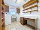 Bright laundry room with work space, shelving, tile flooring, washer, and dryer at 13725 Oak Forest N Blvd, Seminole, FL 33776